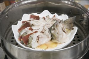 將鱸魚成花狀擺好，將火腿切片放入各縫隙中，放入鍋中隔水蒸12分鐘拿出，撒上蔥花即可。