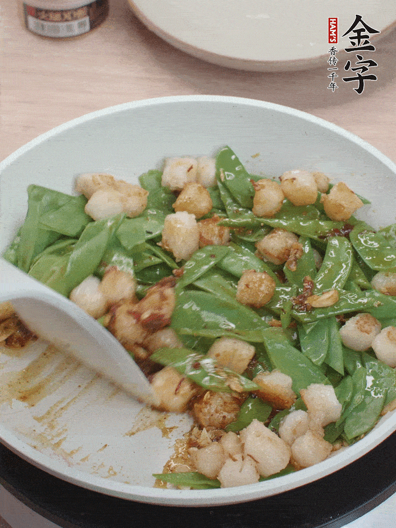 下甜豆莢、鮮貝輕輕翻炒均勻。