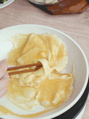 油6成熱時，下雞蛋液，邊緣凝固時翻拌成塊狀。